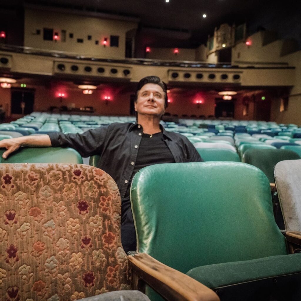 Steve Perry sitting on music show